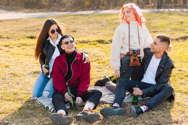 Felizes amigos com cervejas se divertindo juntos na festa ao ar livre