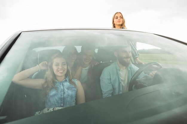 Felizes amigos desfrutando no carro
