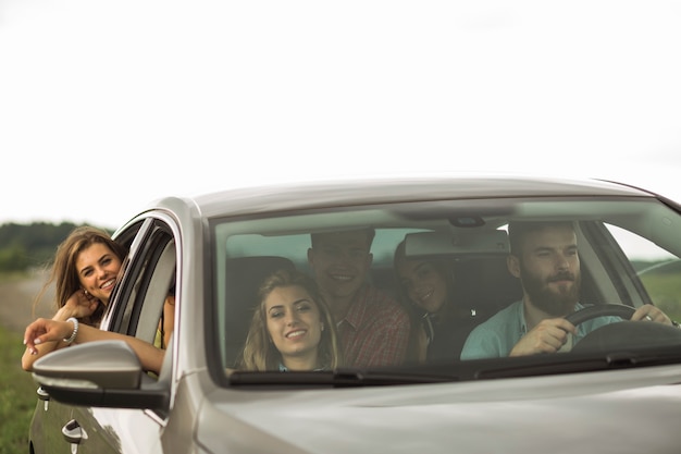 Foto grátis felizes amigos viajando em carro de luxo