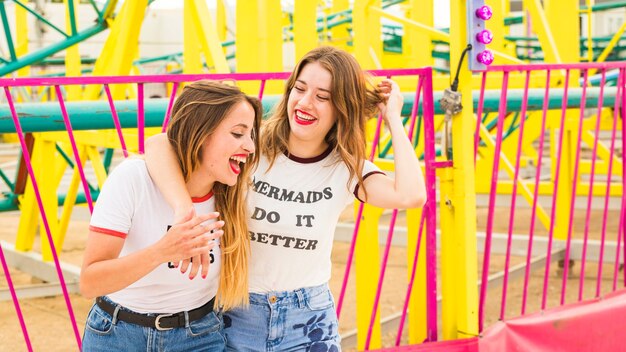 Felizes femininos amigos se divertindo no parque de diversões