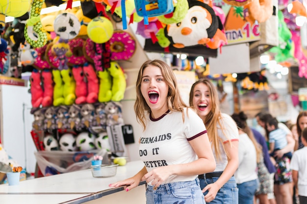 Felizes jovens amigos no parque de diversões