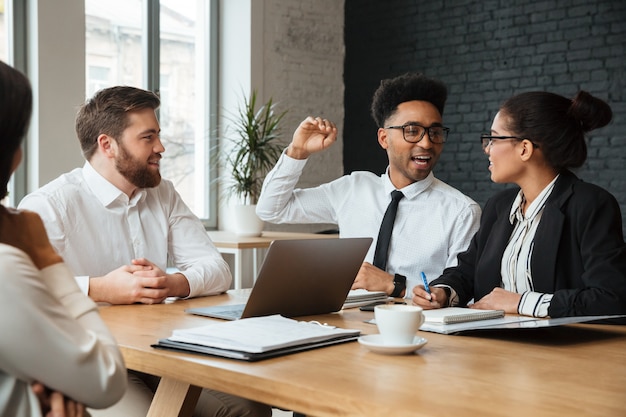 Felizes jovens colegas dentro de casa coworking