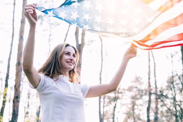 Foto grátis fêmea alegre com bandeira americana nacional