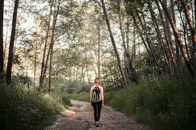 Fêmea com sua mochila caminhadas na floresta