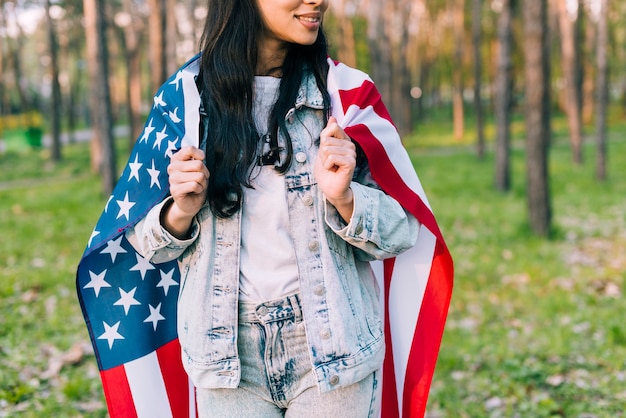 Fêmea na jaqueta jeans com bandeira dos EUA