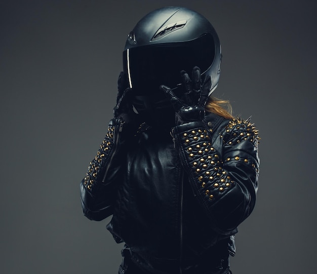 Foto grátis fêmea no capacete da motocicleta e roupas de couro isoladas em fundo cinza em estúdio.