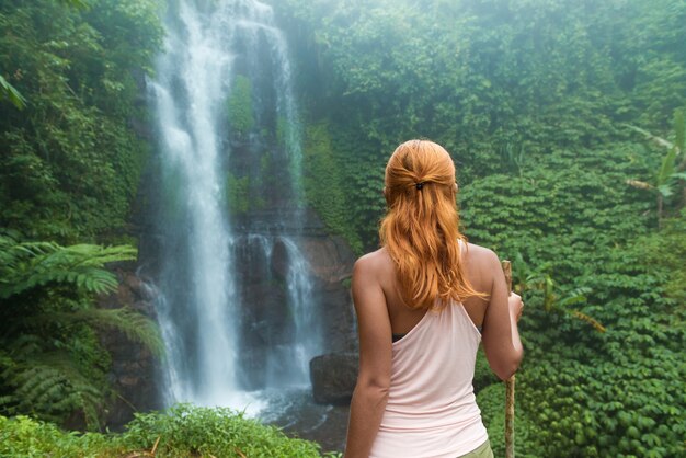 Feminino aventureiro olhando cachoeira