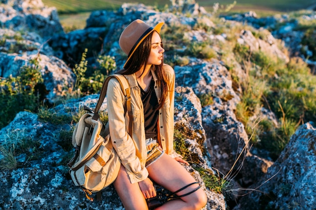 Foto grátis feminino caminhante sentado na rocha