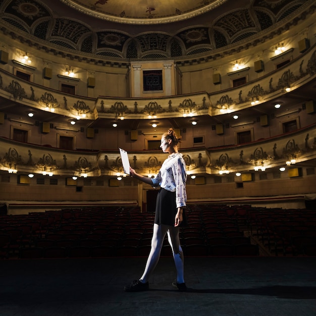 Foto grátis feminino mime lendo manuscrito no auditório vazio