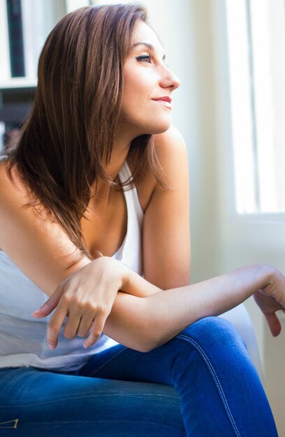 Feminino sentado perto de uma janela em casa