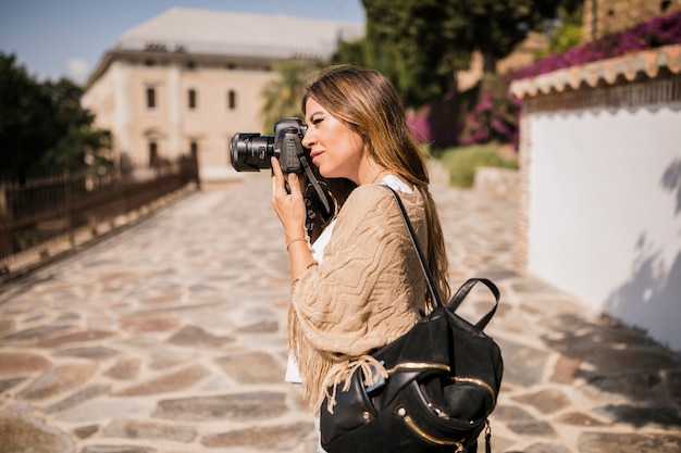 Foto grátis feminino turista tirando foto na câmera