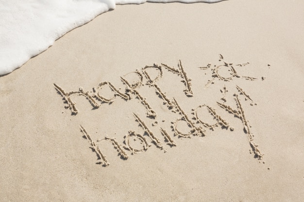 Feriado feliz escrito na areia