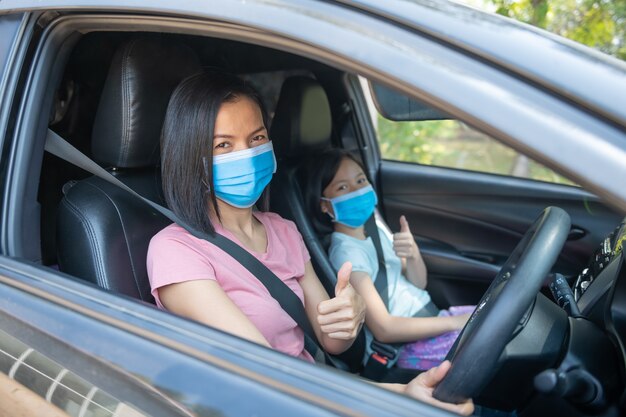 Férias em família, Coronavirus Covid-19 e máscara facial, mãe usando máscara de tecido para filha de menina criança quando. novo normal ficar seguro. passeio de verão de automóvel.