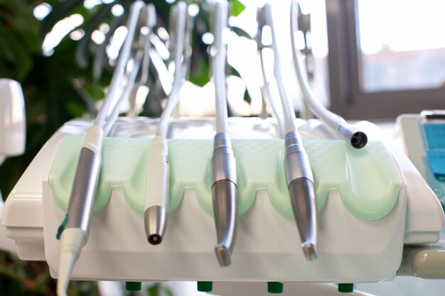 Ferramentas odontológicas com tubos fixados na cadeira odontológica