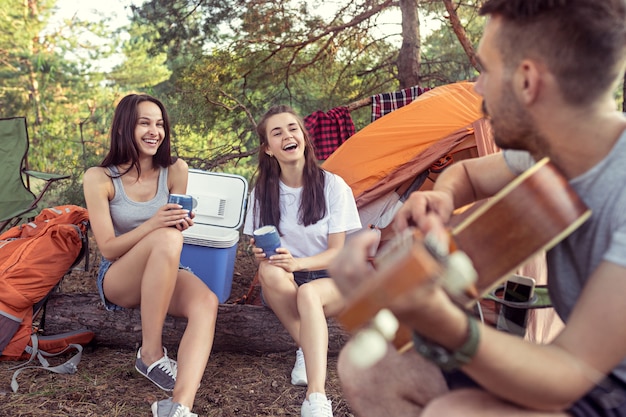 Festa, acampamento de grupo de homens e mulheres na floresta