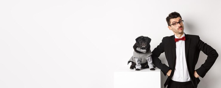 Foto grátis festa de animais e conceito de celebração jovem bonito e cachorro em trajes formais olhando para a câmera