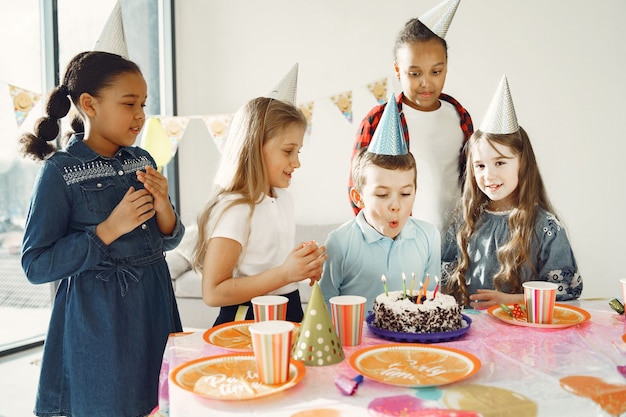 Festa de aniversário engraçada infantil no quarto decorado. Crianças felizes com bolo e balões.