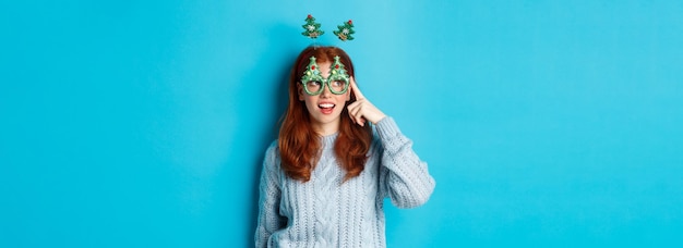 Foto grátis festa de natal e conceito de celebração linda garota adolescente ruiva comemorando o ano novo usando árvore de natal