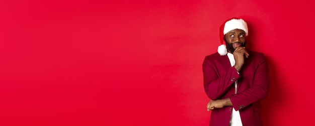 Foto grátis festa de natal e conceito de feriados homem afro-americano sorridente fazendo planos de ano novo olhando para você