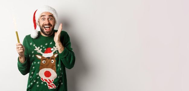 Foto grátis festa de natal e conceito de feriados jovem feliz celebrando o natal de ano novo segurando estrelinha e