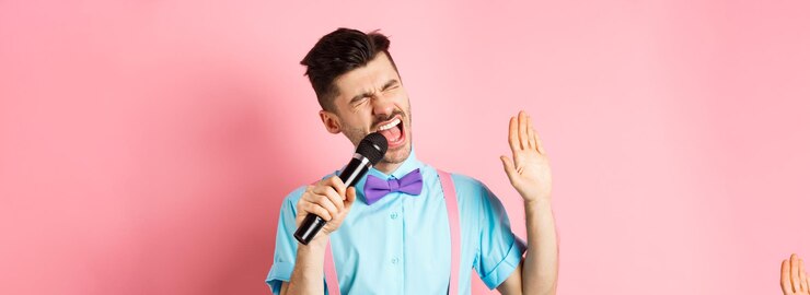 Foto grátis festa e conceito de eventos festivos, o cara engraçado executa uma música cantando karaokê no microfone com carefr