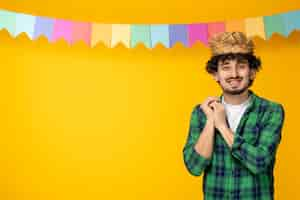 Foto grátis festa junina jovem bonitinho com chapéu de palha e bandeiras coloridas festival brasileiro feliz