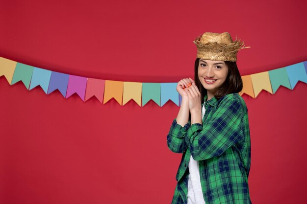 Festa junina linda garota de camisa verde celebrando o festival brasileiro de mãos dadas