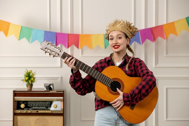 Festa junina linda garota de chapéu de palha no verão brasileiro com bandeiras coloridas de rádio retrô na guitarra