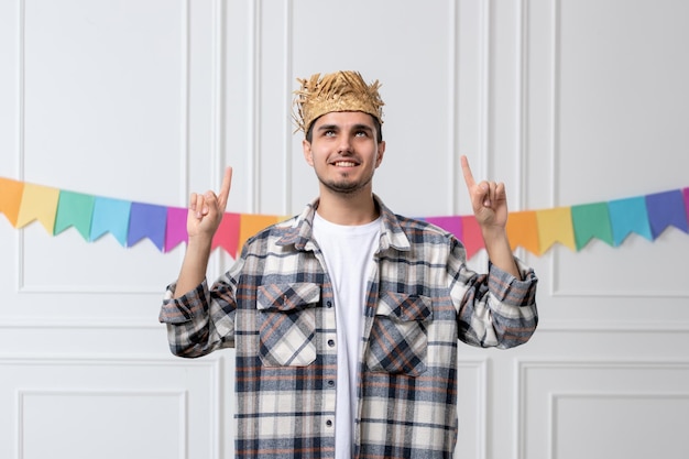 Foto grátis festa junina lindo cara lindo de camisa com chapéu de palha comemorando festival apontando para cima