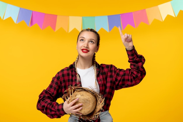 Foto grátis festa junina loira linda garota no festival brasileiro de chapéu de palha com bandeiras coloridas sonhando