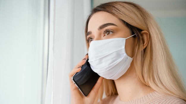 Foto grátis fica dentro de casa mulher falando ao telefone