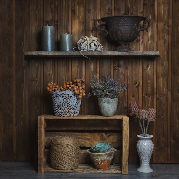 Fidderent cestos e vasos de flores em pé em stands rústicos