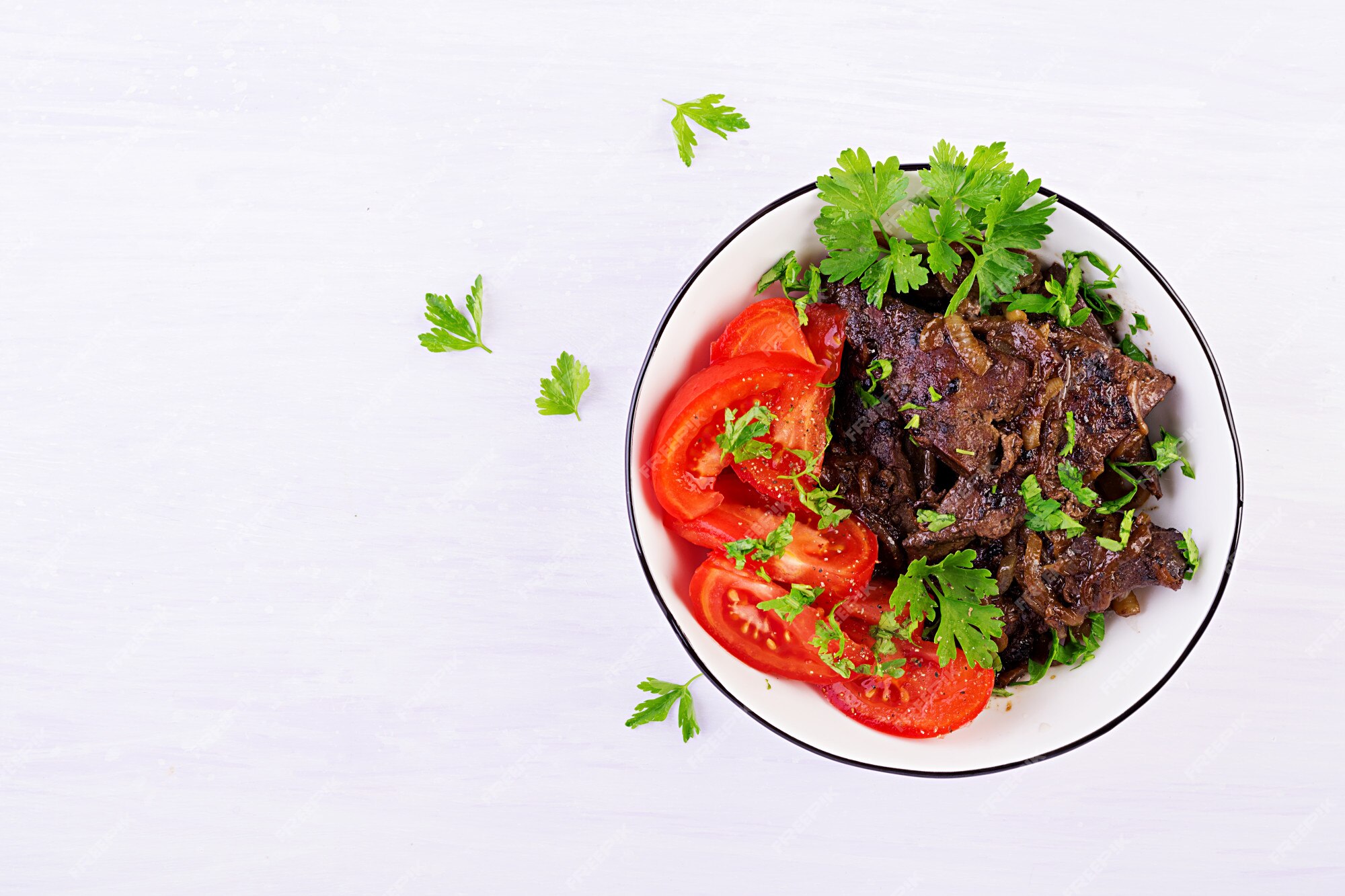 pedaços de fígado frito com cebola, folhas frescas de saladas