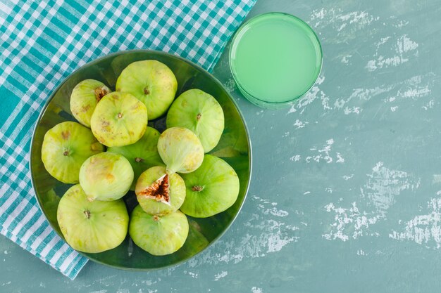Figos verdes em um prato com bebida plana colocar no pano de gesso e piquenique