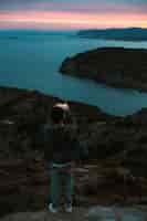 Foto grátis figura solitária de turista ou viajante que fica no topo de um penhasco ou montanha