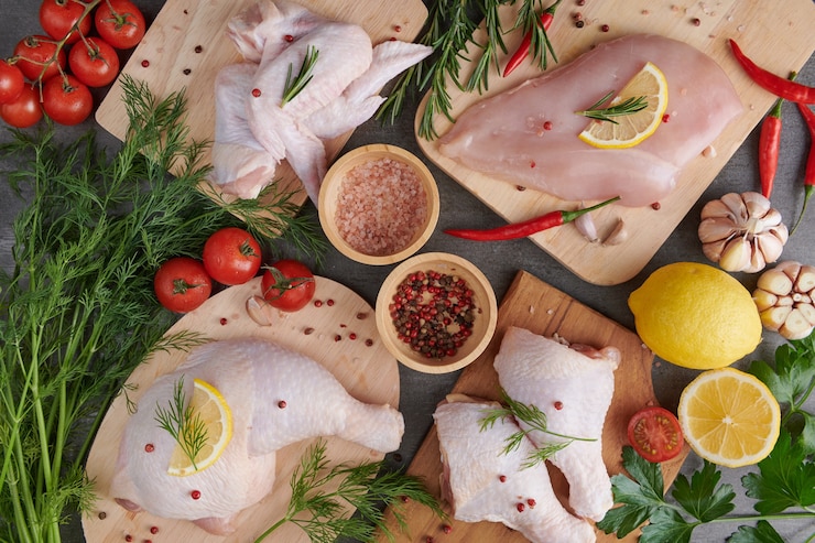 Foto grátis filé de frango cru com alho, pimenta e alecrim na madeira na tábua.