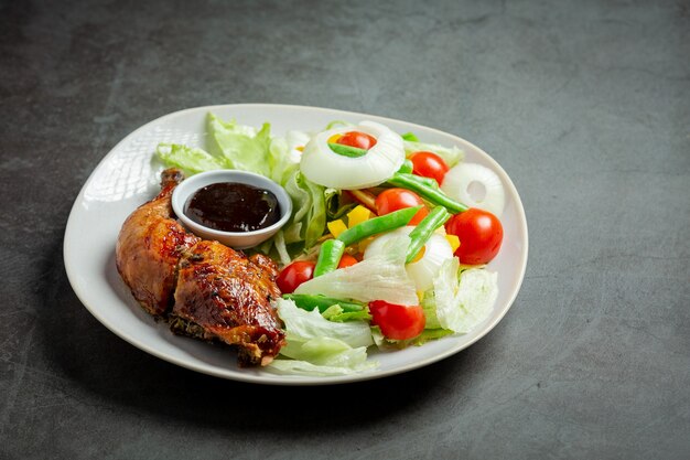 Filé de frango grelhado e vegetais em fundo escuro