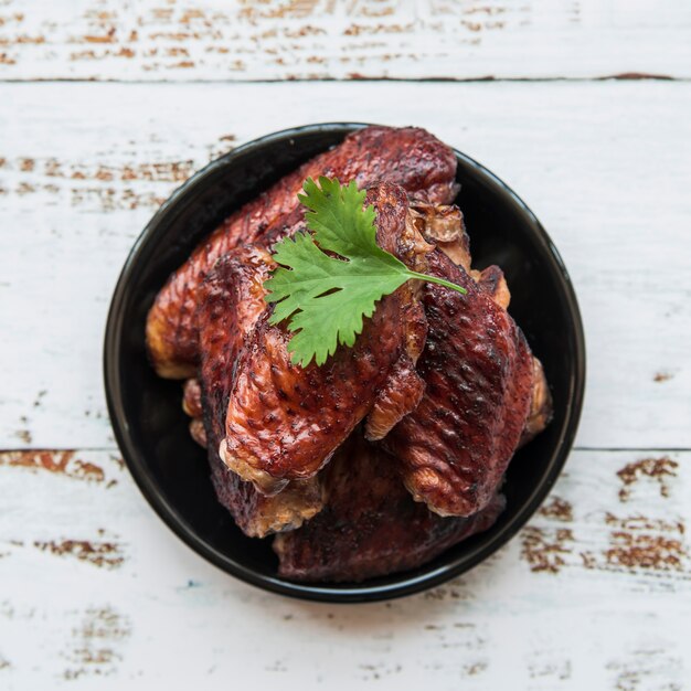 Filé de frango grelhado, guarnecido com coentro na tigela na mesa