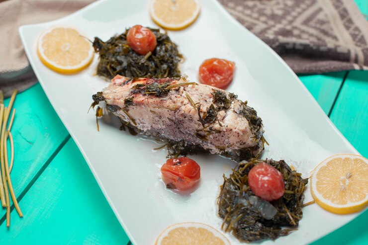 Foto grátis filé de peixe grelhado com salada verde e rodelas de limão