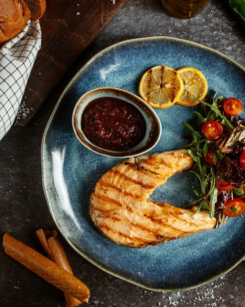 Filé de salmão frito com legumes e rodelas de limão