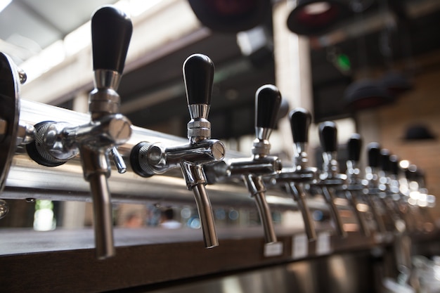 Foto grátis fileira de torneiras de cerveja no bar