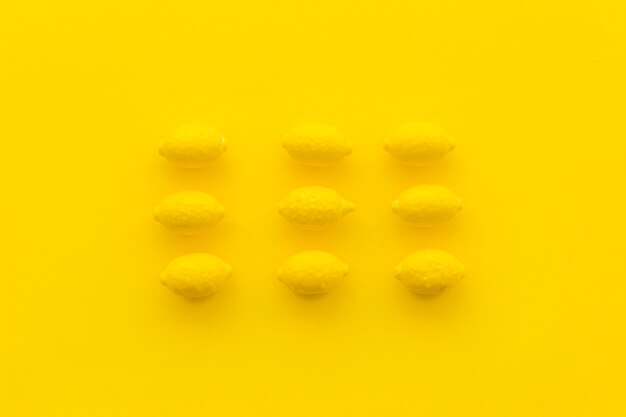 Fileiras de doces de limão no fundo amarelo