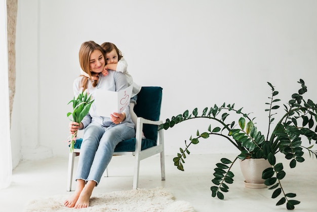 Foto grátis filha, abraçando, mãe, com, cartão cumprimento