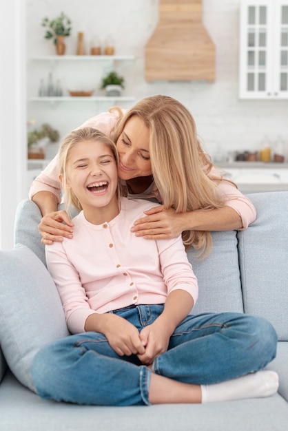 Filha adorável beijada por sua mãe