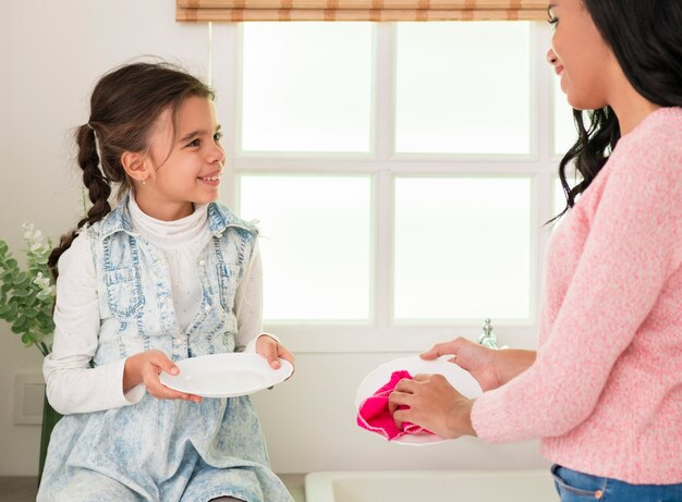 Filha de alto ângulo, ajudando a mãe com a limpeza