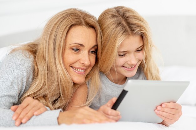 Filha e mãe olhando no tablet