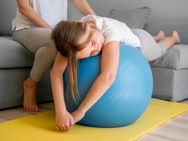 Filha e mãe treinando com bola