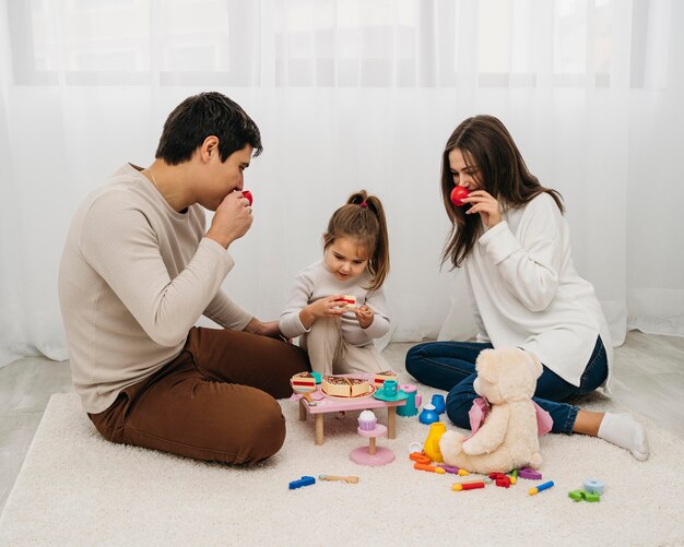 Filha e pais brincando juntos em casa