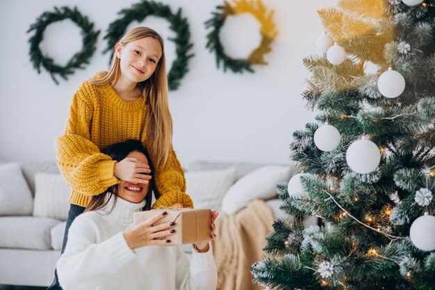 Filha fazendo presente surpresa para a mãe no Natal