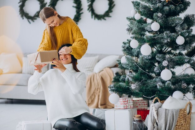 Filha fazendo presente surpresa para a mãe no Natal